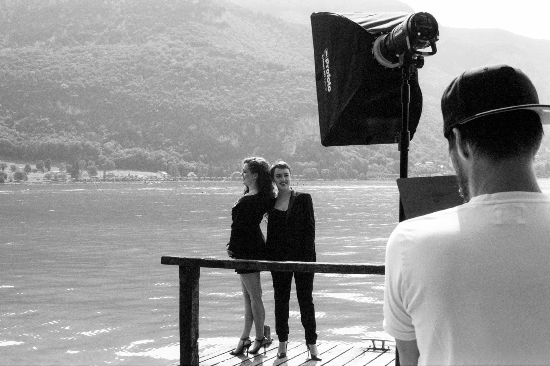 Depuis l'épaule d'un assistant : les deux musiciennes posent devant une boîte à lumière montée sur pied.