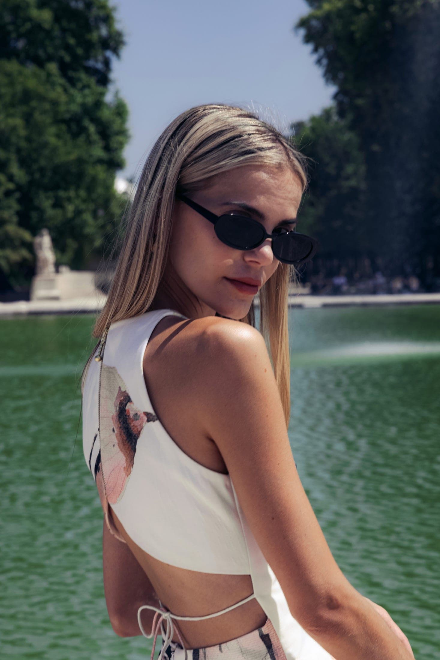 Dos-nu et nœud de la robe en plan rapproché, profil de la mannequin, lunettes ovales.