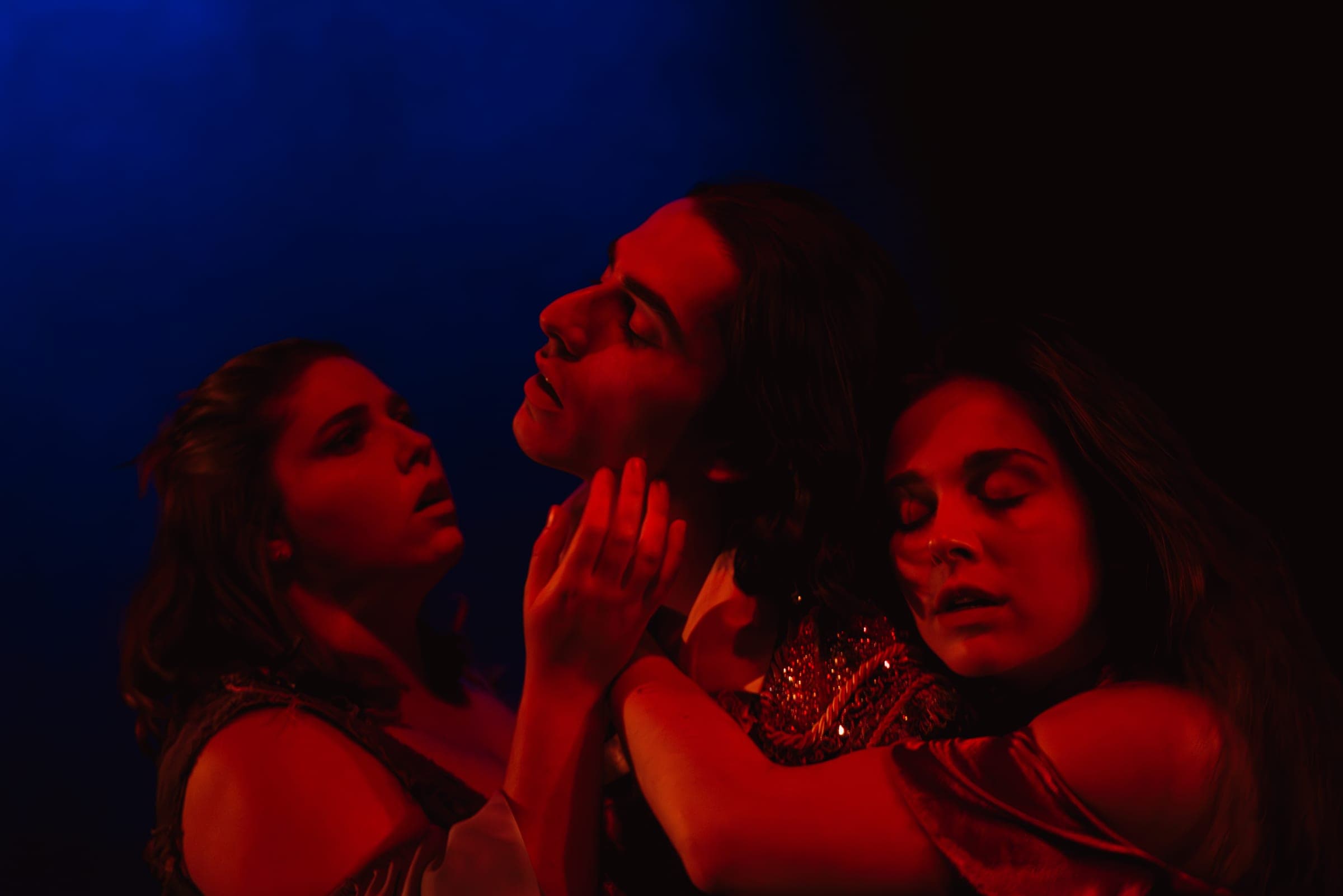 Trois visages serrés dans le même cadre, entre le rouge et le bleu