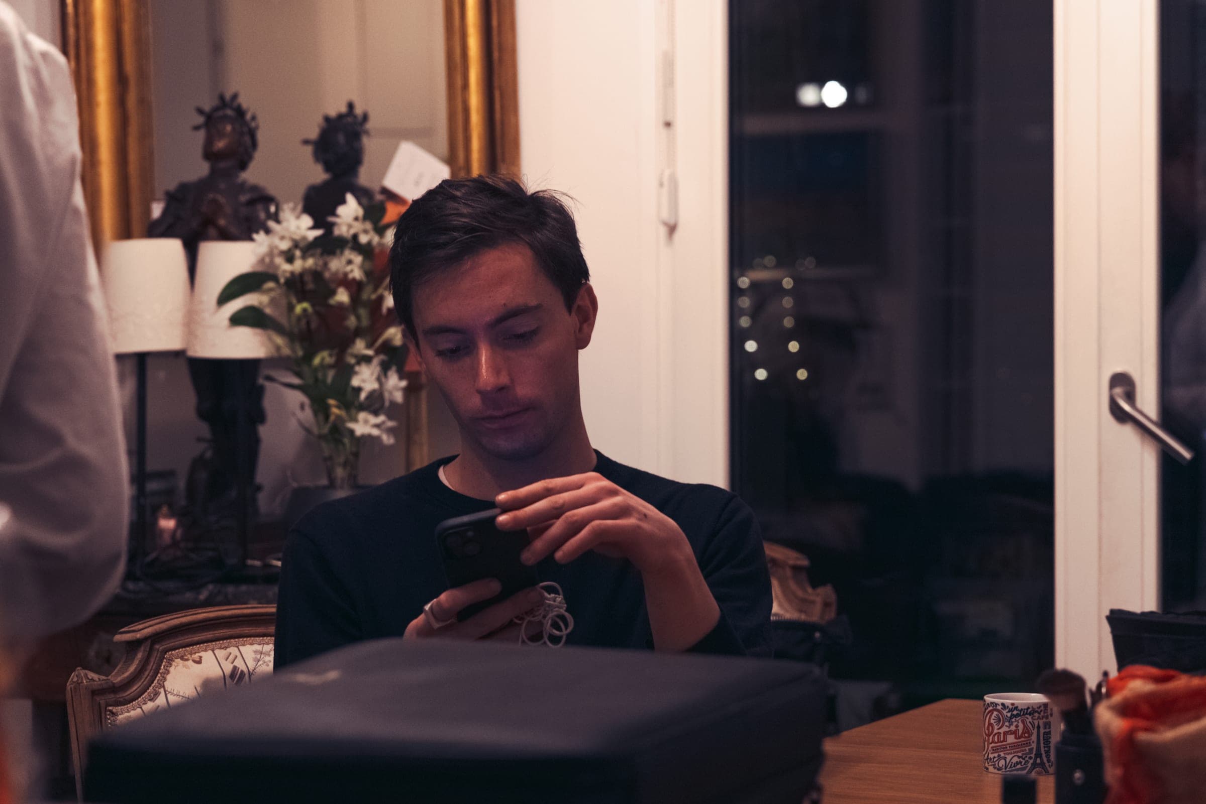 Un homme consulte son téléphone dans le salon transformé en studio