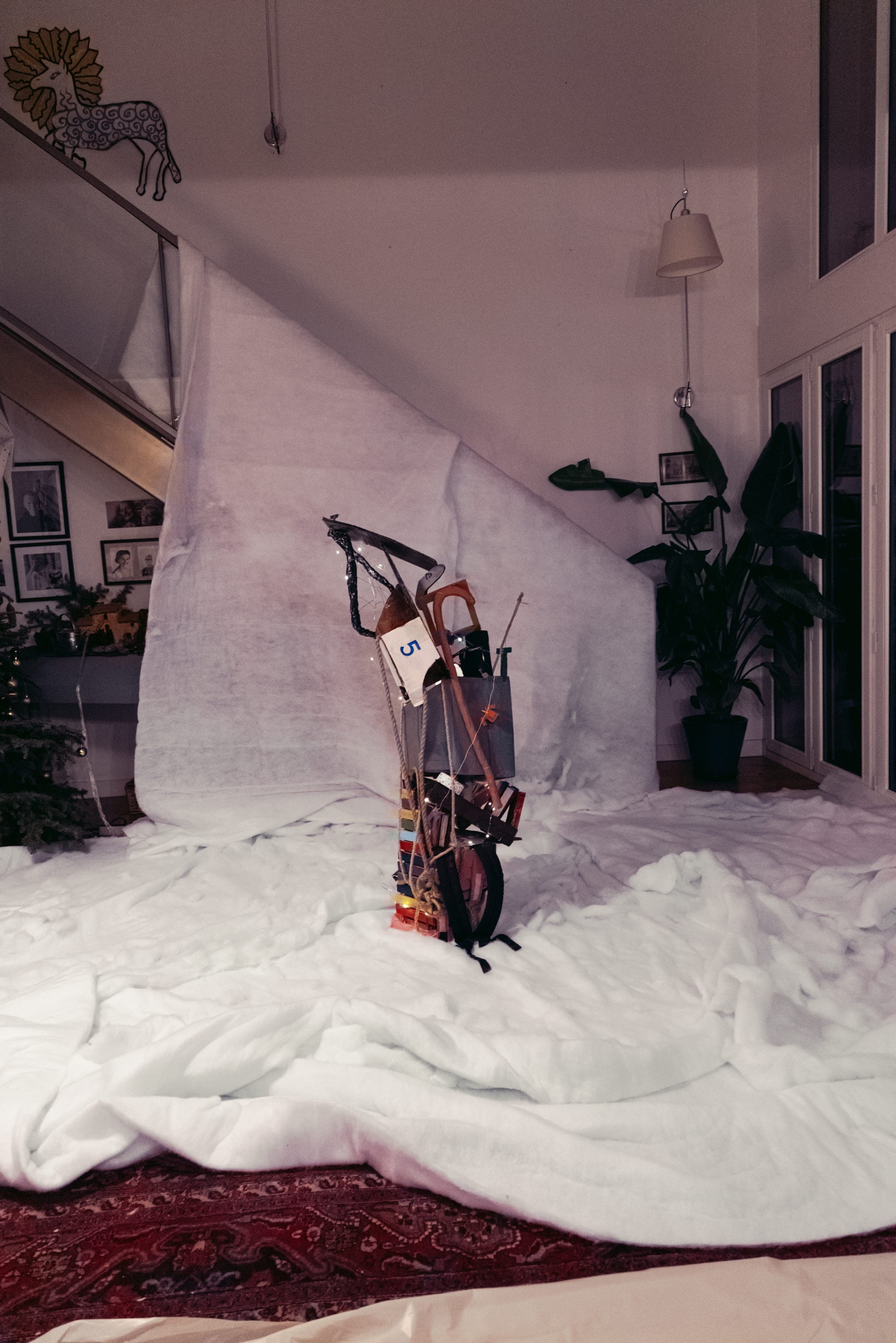 Vue large du décor : toile blanche tendue, neige au sol, la sculpture au centre