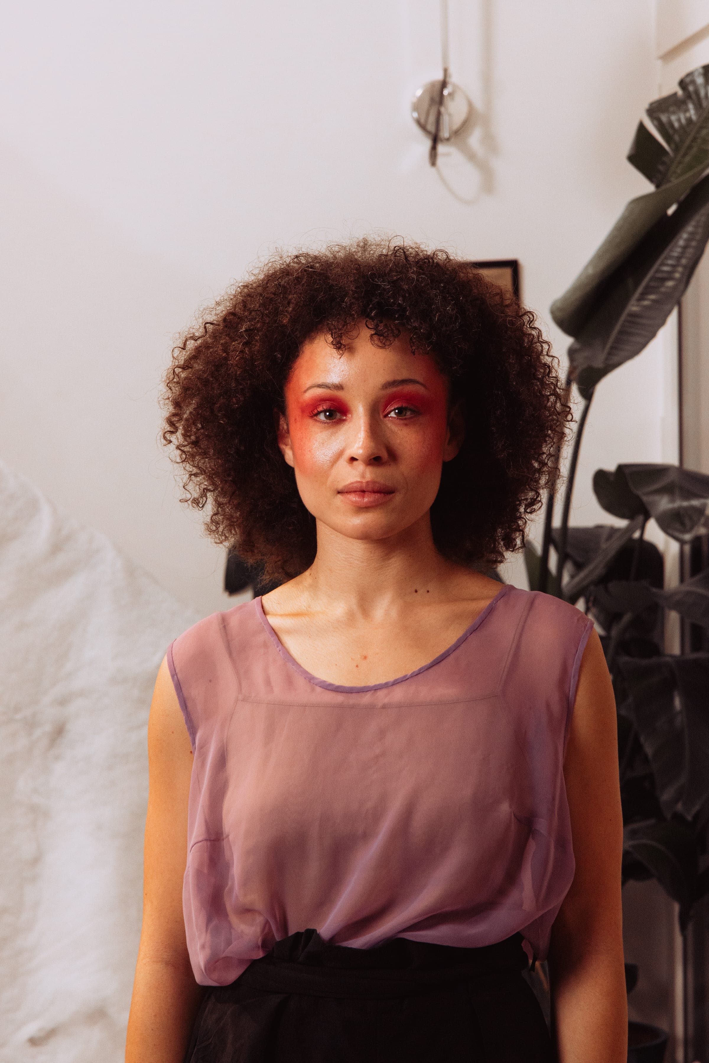 Portrait de la comédienne, fard rouge autour des yeux, débardeur mauve