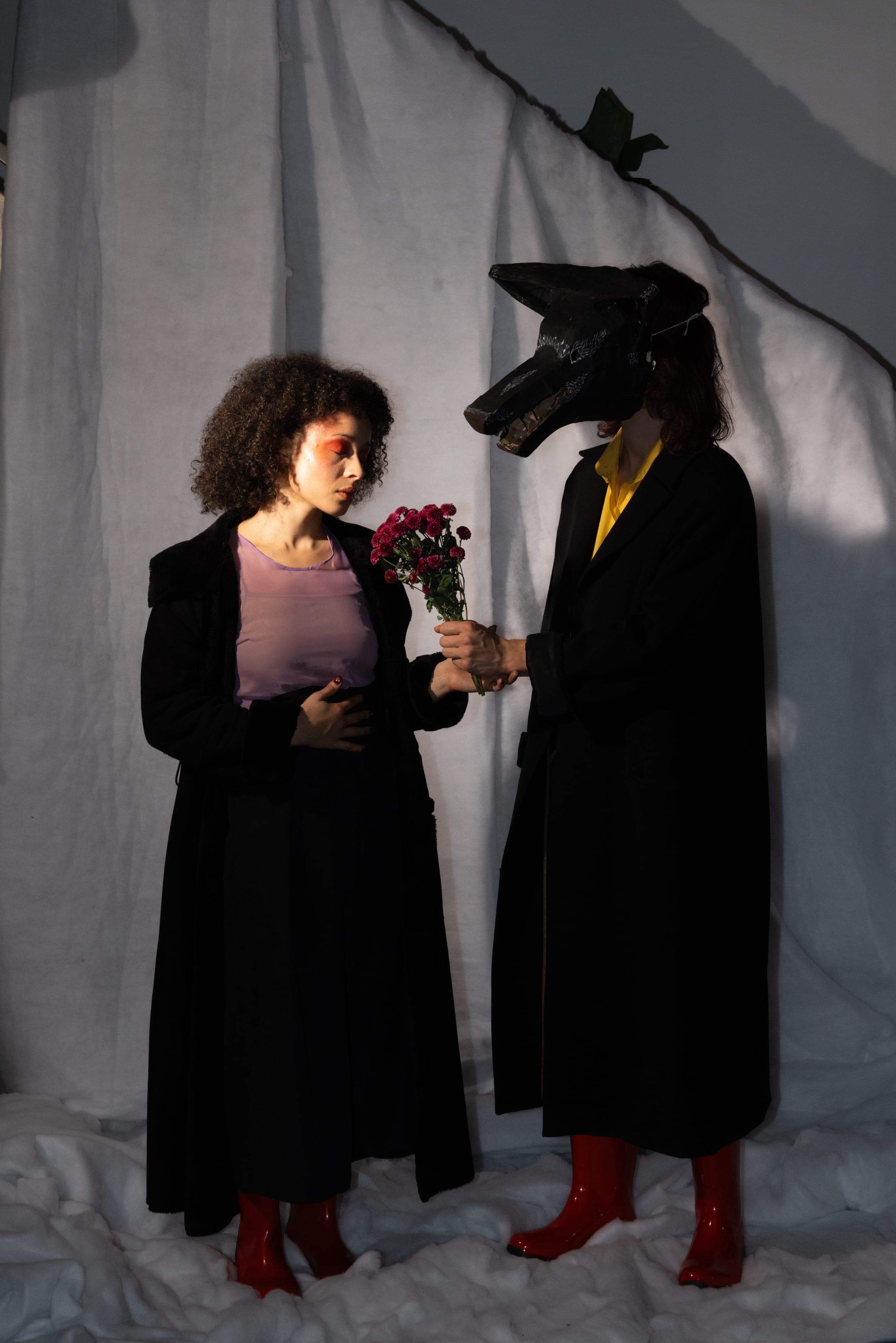 La comédienne baisse les yeux vers le bouquet que lui tend le loup
