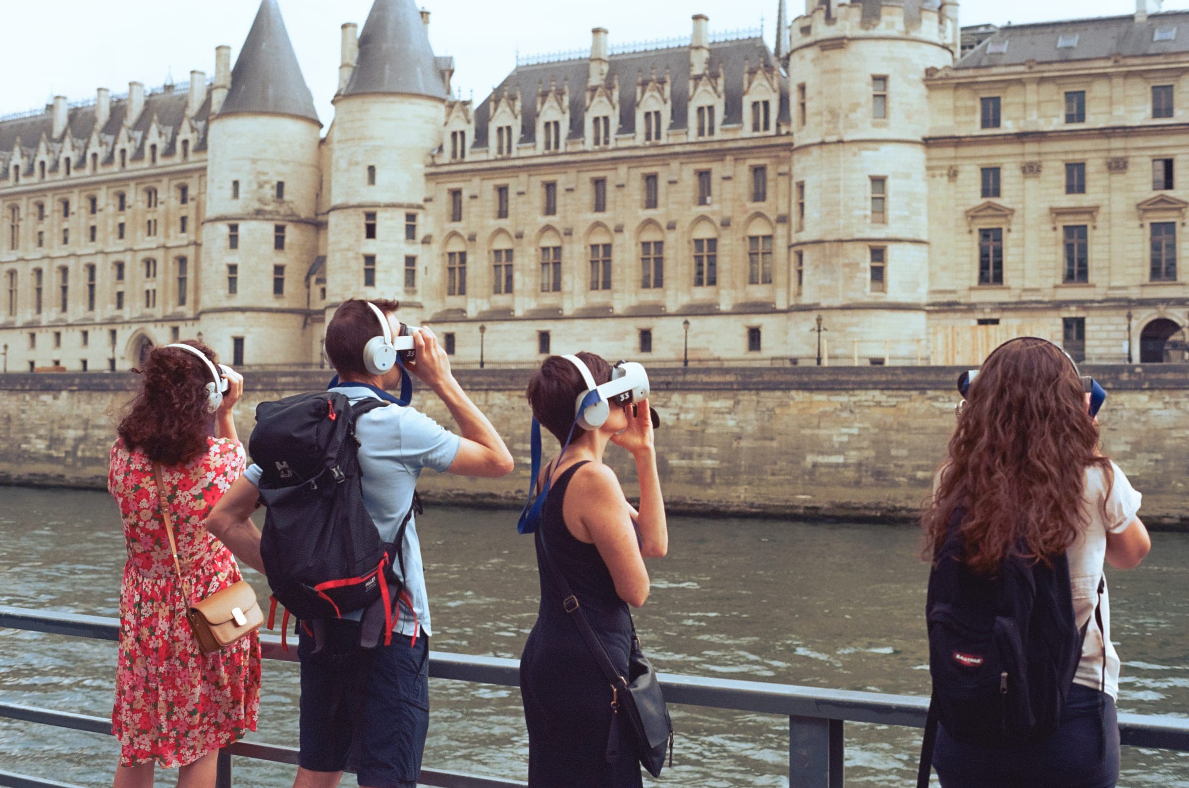 La Conciergerie vue du quai, des touristes accoudés au parapet.