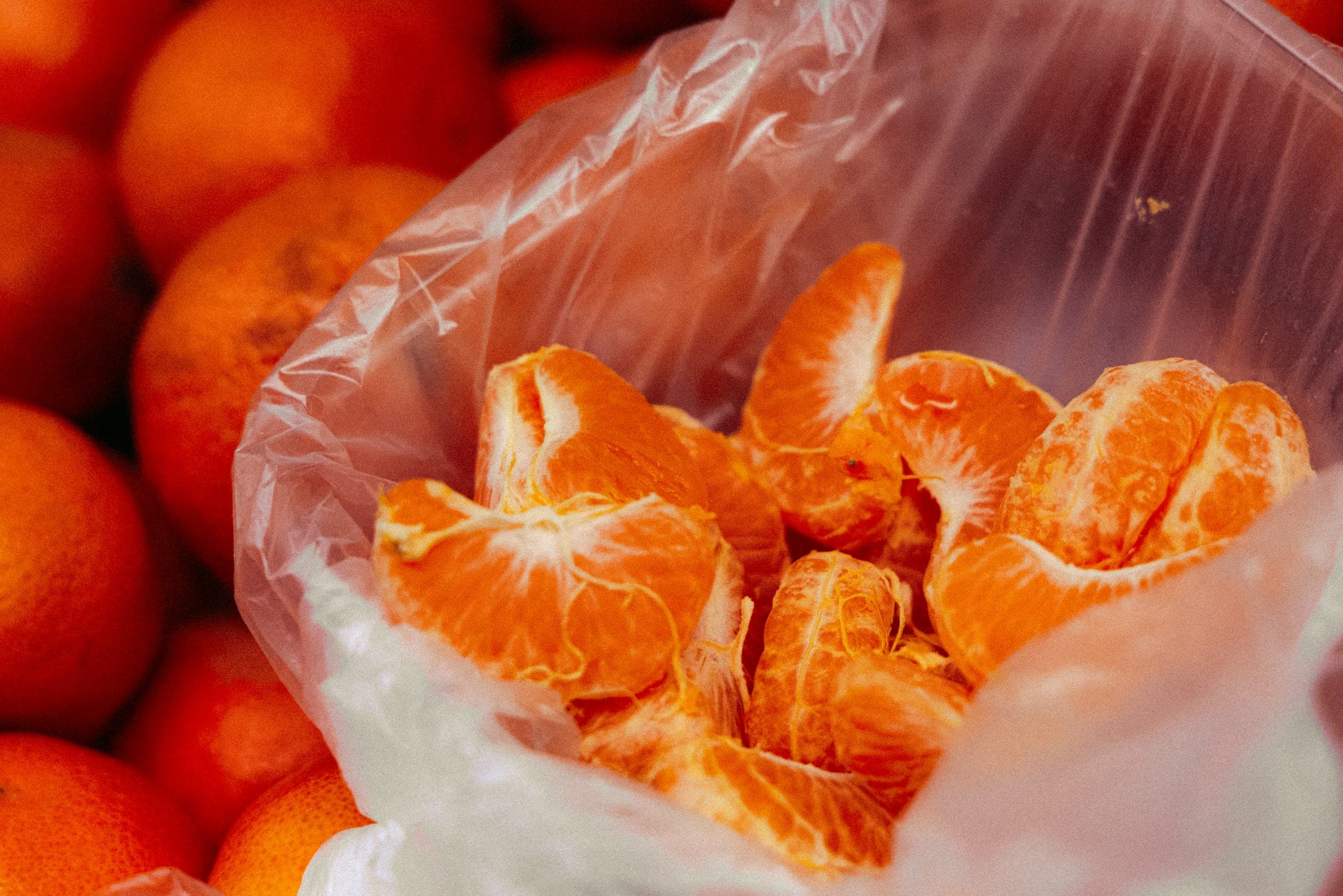 Des clémentines épluchées dans un sac plastique, posé sur l'étal.
