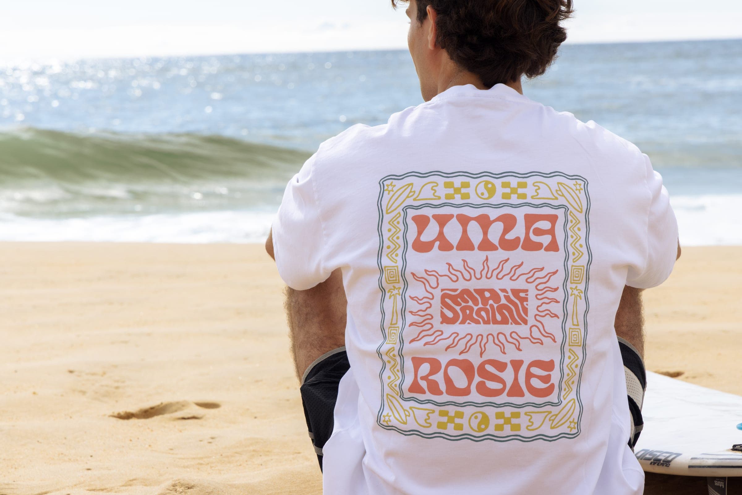 Le t-shirt blanc de dos, sérigraphie encadrée, en bord de vague.